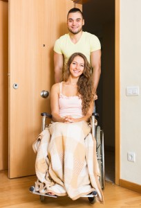 couple with woman in wheelchair near door